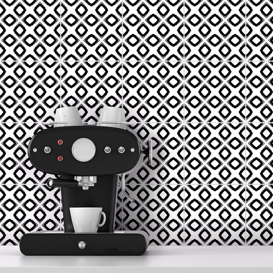 Zwarte en witte etnische Kisangani tegelstickers met ruitpatroon op een muur achter een zwarte espressomachine.
