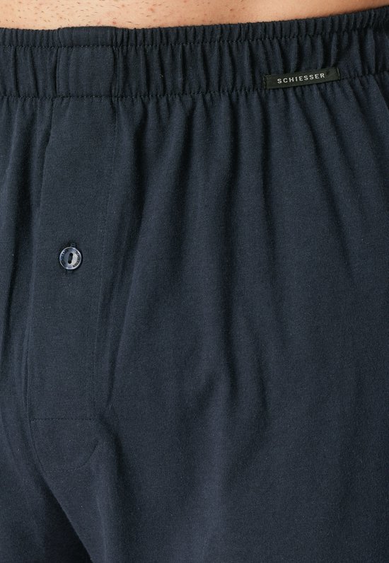 Detail van donkerblauwe boxesshorts met elastische tailleband, knoop en Schiesser-label.