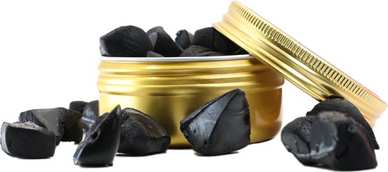 Gouden blik met Raw Shilajit, met brokjes shilajit rondom.