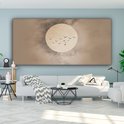 Canvas met beige tinten, zachte cirkel en vogels, in een woonkamer met een grijze bank.
