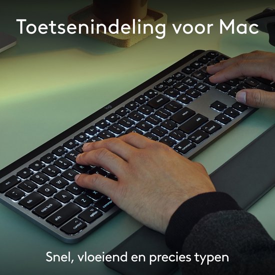 Mains sur un clavier Logitech MX Keys S gris avec disposition Mac et repose-poignets.