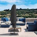Zwarte parasolhoes bedekt een grote zweefparasol, staand op een terras met tuinmeubelen.