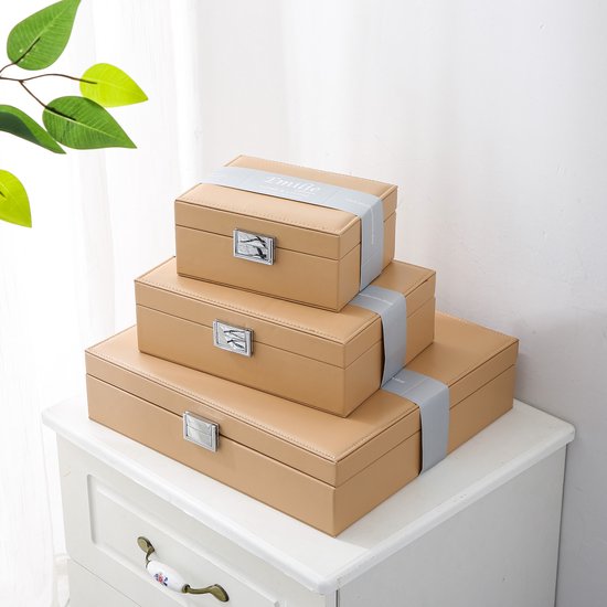 Drie beige opbergdozen van de Emilie Collection, gestapeld en verbonden met grijze linten.