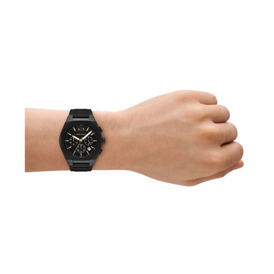 Zwart Armani Exchange horloge met gouden wijzers om de pols gedragen.