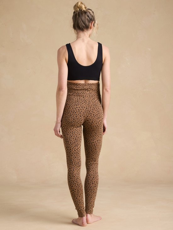 Model van achteren gezien in bruine legging met luipaardprint en zwarte sportbeha.