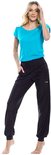 Model in een zwarte, comfortabele joggingbroek met een elastische tailleband en logo op de heup. Ze draagt een turquoise T-shirt.