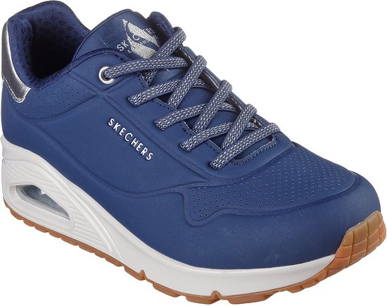 Schuin aanzicht van de donkerblauwe Skechers sneaker, voorzien van zilverkleurige tong en hielversteviging.