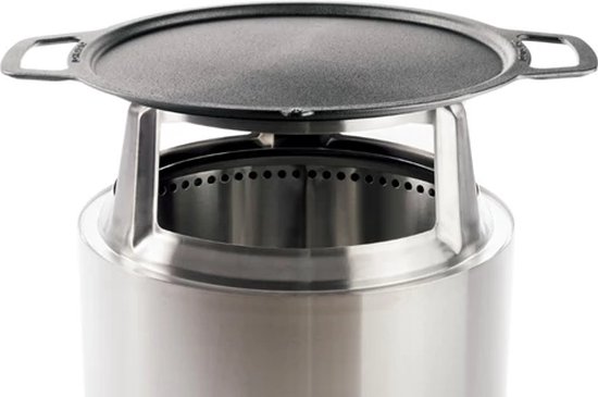 Ronde gietijzeren plancha met handvatten op een metalen Solo Stove vuurkorf.