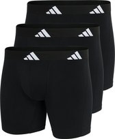 Drie zwarte boxen op elkaar gestapeld, elk met een brede zilverkleurige Adidas band.