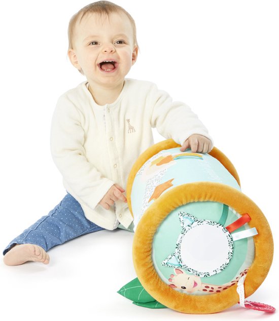 Een lachende baby zit naast de rollende speelrol. De rol is mintgroen met oranje uiteinden en heeft een patroon van bladeren en sterren.