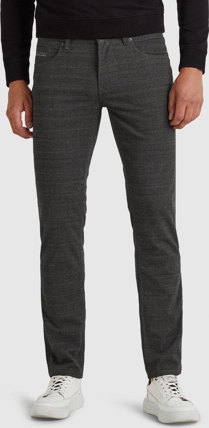 Donkergrijs plaid skinny herenjeans met gele accenten. Model draagt zwarte trui en witte sneakers.
