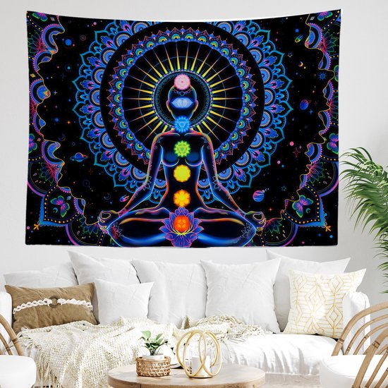Een woonkamer met een witte bank en een salontafel, waaraan een grote wanddecoratie met een mandala en yogi hangt.