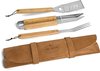 Un set de barbecue 4 pièces avec manches en bois, comprenant spatule, pince, couteau et fourchette, sur fond noir. Le set est enroulé dans une pochette en cuir marron avec le logo "Grill Master".