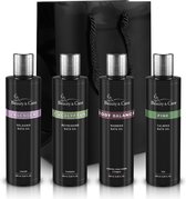 Vier zwarte flessen badolie van Beauty & Care: Lavender, Eucalyptus, Body Balance en Pine, met een zwarte geschenkzak erachter.