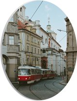 PVC Schuimplaat Ovaal - Roodkleurige Tram rijdend door de Straten van de Stad - 21x28 cm Foto op Ovaal (Met Ophangsysteem)