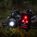 Gros plan sur le dos d'un coureur portant une lampe de poitrine rouge.
