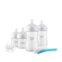 Set van vier witte Philips Avent babyflessen, een witte fopspeen en een blauwe flessenborstel.