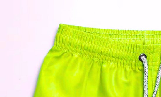 Elastische tailleband met trekkoord van een neongroene zwemshort.