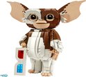 Een LEGO Ideas Gizmo figuur, gemaakt van bruine en witte blokjes, met grote oren en grote ogen. Hij houdt een witte 3D-bril vast.