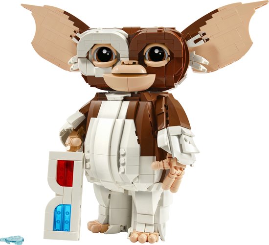 Een LEGO Ideas Gizmo figuur, gemaakt van bruine en witte blokjes, met grote oren en grote ogen. Hij houdt een witte 3D-bril vast.