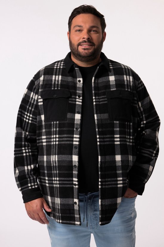 Man met gebogen rug, draagt een zwart overhemd met ruiten, een zwarte t-shirt en een spijkerbroek.