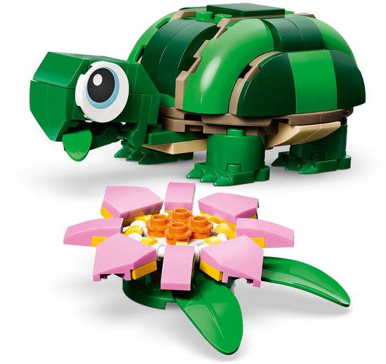 Groene LEGO-schildpad met grote ogen, naast een roze waterlelie.