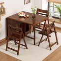 Bruine, inklapbare eettafel met vier stoelen, gedeeltelijk uitgeschoven, opgesteld op een kleed.