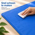 Hand veegt blauwe koelmat schoon met witte doek. Tekst: Snel schoon te maken.