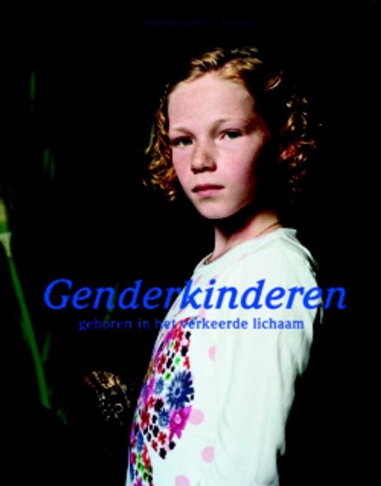 Een meisje met sproeten, rood haar en krullen, draagt een wit shirt met een bloemenprint in roze, blauwe en witte tinten. De tekst 'Genderkinderen' staat in blauwe letters op de voorkant.
