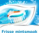 Close-up van een tandenborstel met witte, blauwe en rode tandpasta. Bubbeltjes en glinsterende effecten op een blauwe achtergrond. 'Frisse mintsmaak'.