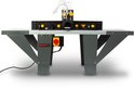 Grijze bovenfreestafel met zwarte machinebehuizing, transparante afzuigkap en gele hendel met rode noodstopknop.