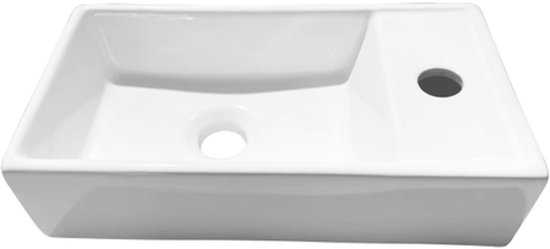 Lavabo en céramique blanc avec robinetterie à droite et trop-plein.