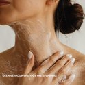 Schouder en nek van een vrouw met zeepsop en een hand die zachtjes streelt.