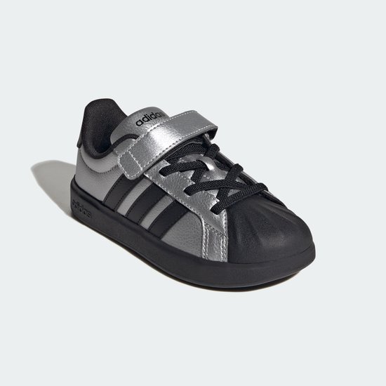 Zilverkleurige sneaker met zwarte strepen, klittenband en neus. Adidas logo.