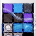 Gedetailleerd zicht op Connetix magneetblokken met paarse, blauwe en grijze glittertegels en transparante buizen van een knikkerbaan.