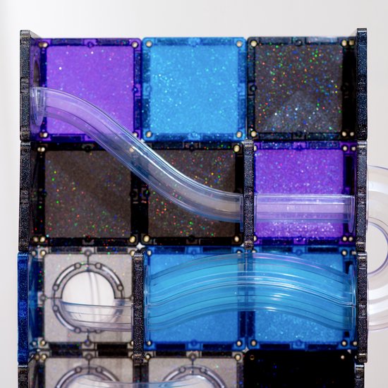 Gedetailleerd zicht op Connetix magneetblokken met paarse, blauwe en grijze glittertegels en transparante buizen van een knikkerbaan.
