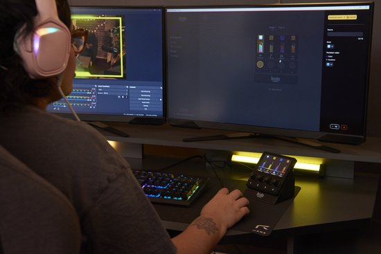 Streamer aan het werk, met twee monitoren waarop streaming software draait, en de Hercules Stream controller op het bureau.