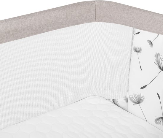 Close-up van beige co-sleeper met gaas en paardenbloemenprint.