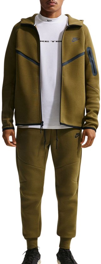 Man met groene Nike Tech Fleece hoodie en bijpassende broek, wit T-shirt met Nike logo.