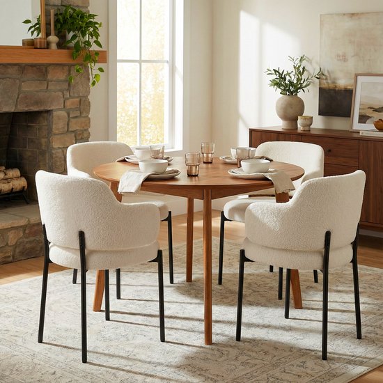 Eettafel met vier witte teddy fleece eetkamerstoelen, elk met een gebogen rugleuning en zwarte metalen poten.