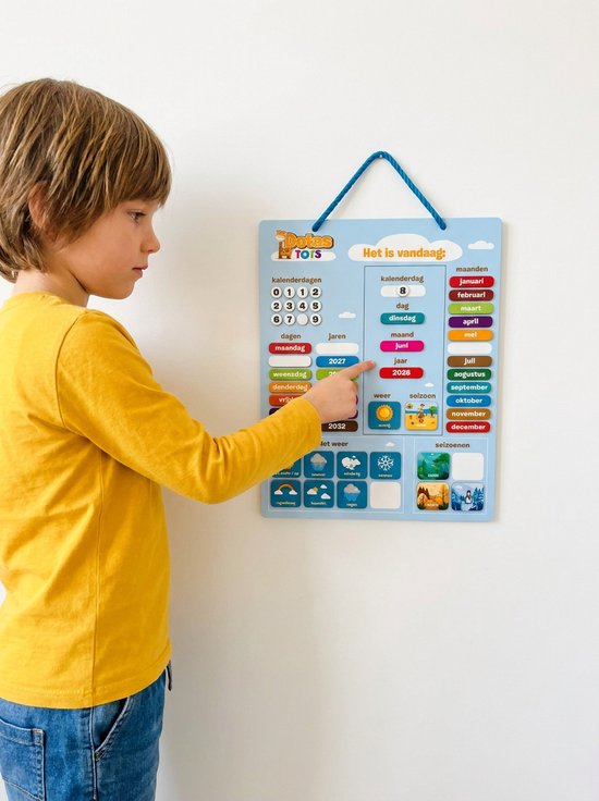 Jongen met gele trui wijst naar een magnetische kalender met dagen, maanden, weer en seizoenen.