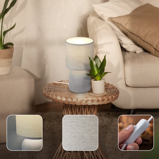 Lampe de table grise avec abat-jour en tissu et base en céramique côtelée, dans un salon, avec des gros plans de la lampe.