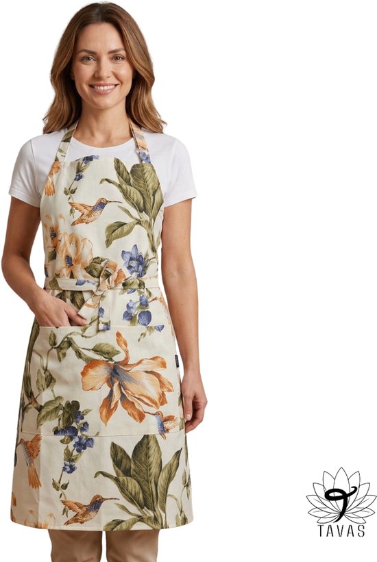 Femme portant un tablier à imprimé floral et oiseaux, avec une poche devant et un nœud à la taille.