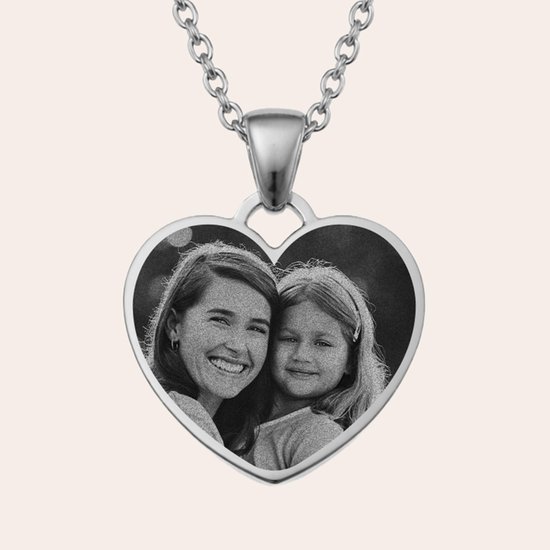 Pendentif cœur argenté avec photo d'une femme souriante et d'une jeune fille.