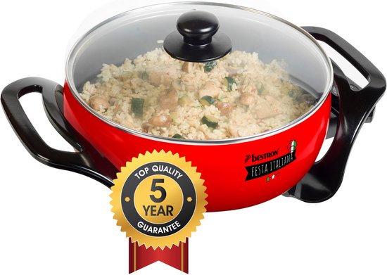 Rode elektrische pan met glazen deksel, gevuld met rijst en groenten. Bevat een 'Top Quality 5 Year Guarantee' sticker.