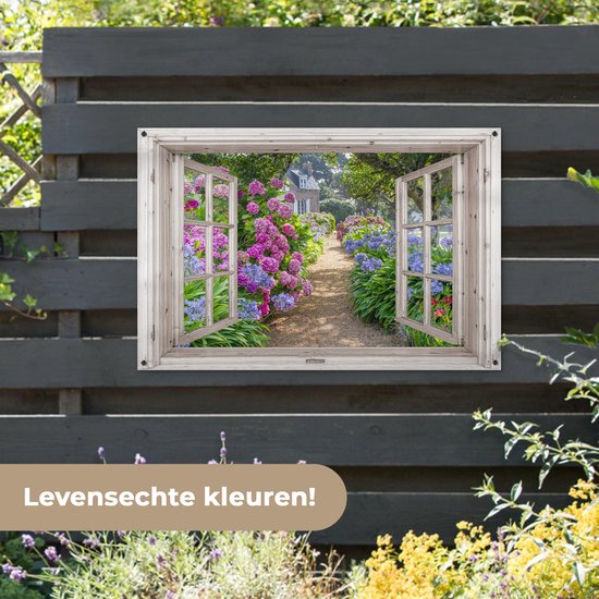 Une fenêtre avec volets ouverts donne sur un chemin aux fleurs roses et violettes.