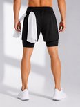 Vue arrière d'un homme portant un short de sport noir avec une serviette blanche dans la boucle arrière.