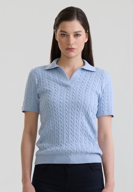 Gros plan d'un mannequin portant un polo bleu clair à manches courtes et motif torsadé.