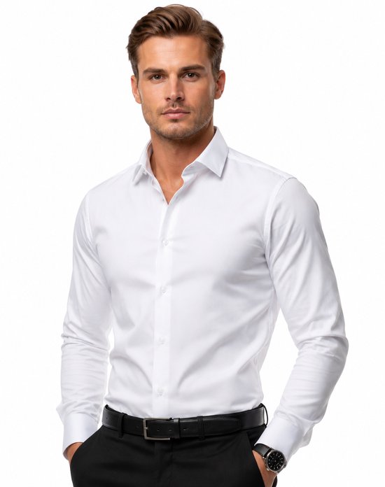 Man in wit overhemd met zwarte broek, handen in zakken.