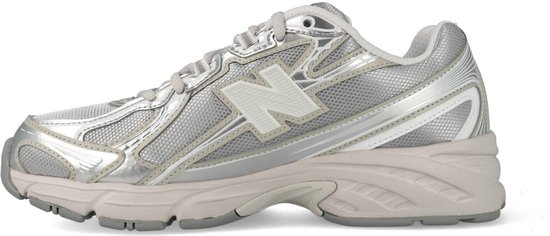 Een lichtgrijze New Balance 740 sneaker met metallic zilveren accenten, van de zijkant gezien.